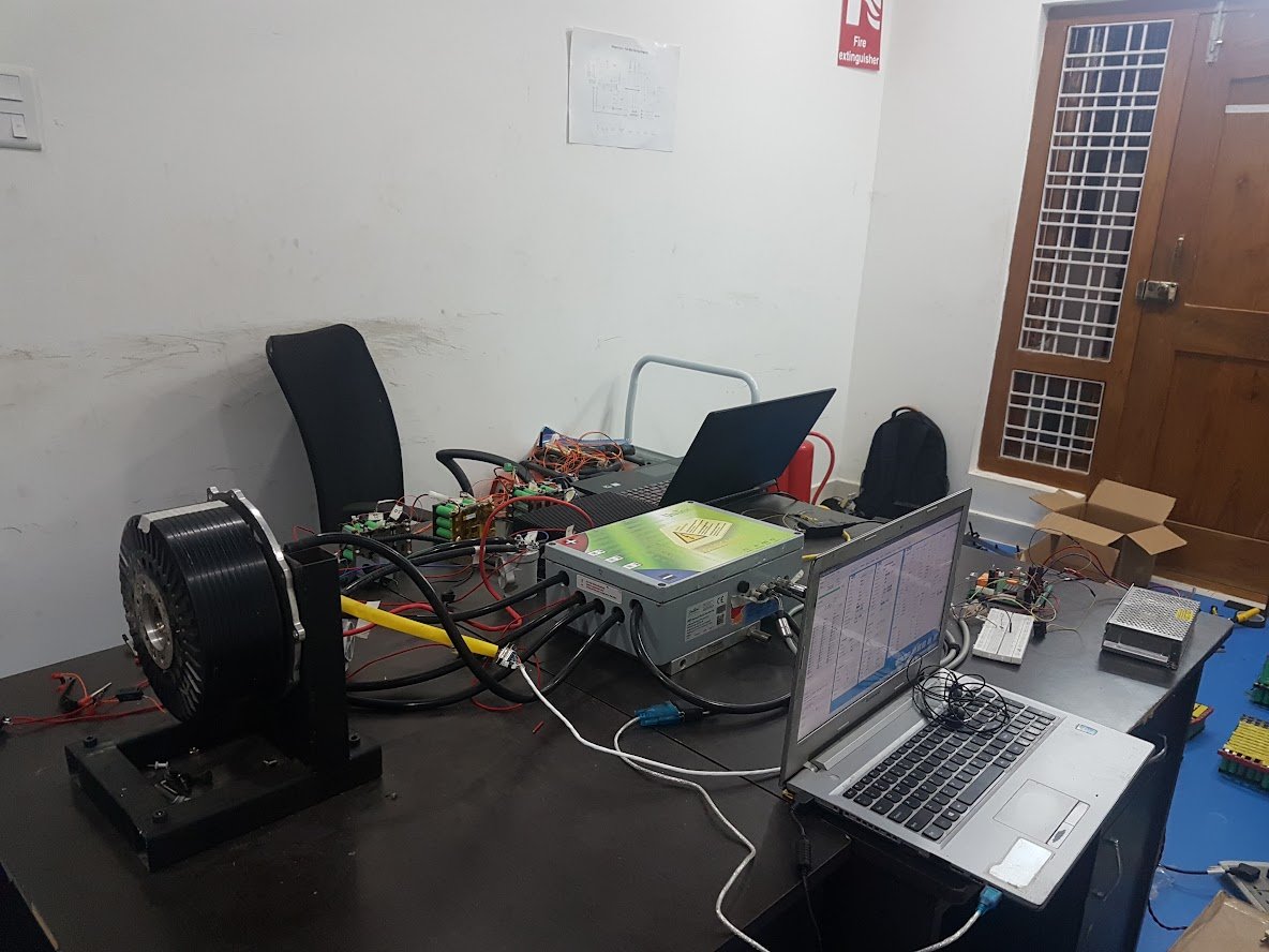 Powertrain bring-up bench with motor, controller, cell modules and tuning laptop — photograph, October 2018